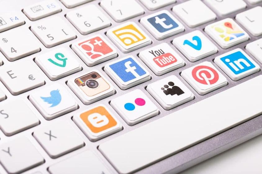 Social media logo collection printed and placed on a modern computer keyboard.