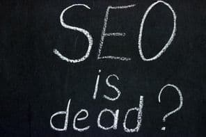 Is SEO dead? inscription on a chalk board against a dark background.